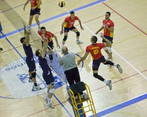 스페인 남자 배구 국가대표팀 선수(18번, 붉은색 유니폼)가 포르투갈 남자 배구 국가대표팀 선수들이 블로킹을 하는 동안 스파이크를 하려는 모습