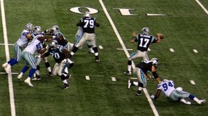 쿼터백이 포워드 패스를 던지는 모습. 그의 오펜시브 라인맨들이 그의 앞에 있다.