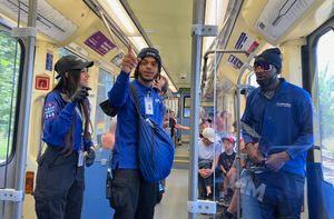 경전철에서 대화하는 세 명의 직원