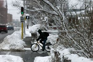 눈 속에서 신호등에서 기다리는 자전거 이용자