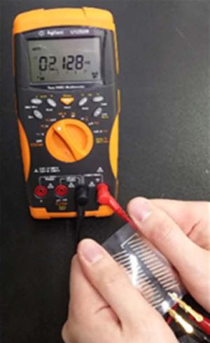 유연한 PEDOT:PSS 열전 소자의 양쪽을 잡아 전기를 생성하는 모습