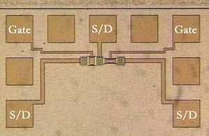 시험 패턴에 있는 두 개의 금속 게이트 MOSFET의 현미경 사진. 두 개의 게이트와 세 개의 소스/드레인 노드에 대한 프로브 패드가 표시되어 있다.