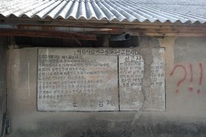 오래된 건물 벽에 쓰여 있는 거동수상자 신고안내문