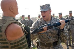 미국 공군 훈련생이 탄약이 없는 M16 소총으로 표적 더미를 내려치고 있다