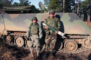 조지아주 포트 베닝에서 2006년 2월, M1064 박격포 운반장 앞에 서서 XM395 정밀 유도 박격포탄 시제품을 들고 있는 병사들