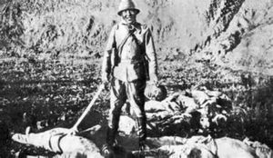 일본군 병사가 자신의 희생자의 잘린 머리를 들고 포즈를 취하고 있다.