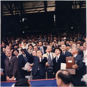 1961년 그리피스 스타디움에서 열린 프로 야구 시즌 개막일. 존 F. 케네디 대통령이 첫 공을 던지고 있으며, 존슨 부통령(왼쪽)과 휴버트 험프리도 보인다.