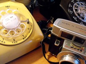 1960년대 기술의 예시: 회전식 다이얼 전화 두 대와 코닥 카메라
