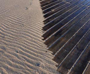 사구의 잔물결과 판자들이 대칭적인 패턴을 형성하고 있다.