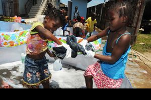 수리남 파라마리보의 고아원이자 보육시설 겸 방과후 시설인 노스카기타에서 아이들이 빨래에서 물을 짜고 있다.