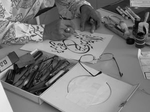 말레이시아의 말레이시아계 무슬림이 쓴 아랍 서예. 서예가는 밑그림을 그리고 있다.