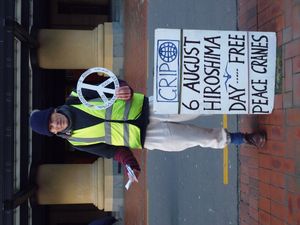 웰링턴에서 핵무기 폐기 운동가가 평화의 학종이를 나눠주고 평화 상징을 들고 있는 모습(2014년 8월 6일 히로시마와 나가사키 원자폭탄 투하 기념).