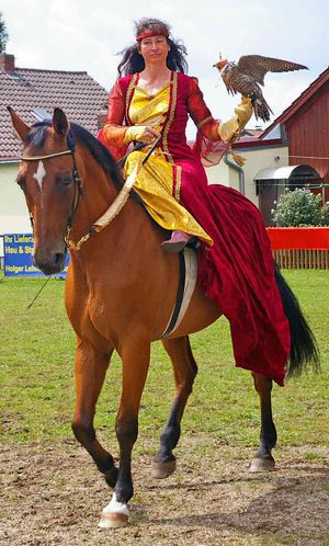 매를 든 여인이 말을 타고 있다