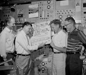 1961년 4월, 주기율표의 103번 원소 위치에 "Lw"라고 적어 주기율표를 갱신하는 기올소. 공동 발견자인 왼쪽부터 라티머, 시켈란드, 라르시가 지켜보고 있다.