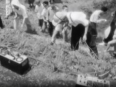 금속탐지기를 사용하여 시모야마의 유류품을 수색하는 경시청 수사관