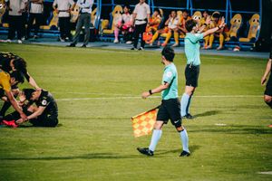 축구 경기 중 심판의 모습. 깃발을 들고 있는 사람이 부심이다.