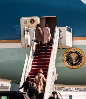 2015년 3월 7일, 말리아와 사샤 오바마가 에어포스원(Air Force One)에 오르기 위해 준비하고 있으며, 미셸 오바마와 버락 오바마 대통령이 뒤에 서 있다.