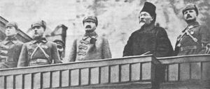 왼쪽부터 안드레이 부브노프, 클리멘트 보로실로프, 레프 트로츠키, 미하일 칼리닌, 미하일 프룬제가 1924년 11월 7일 모스크바 붉은 광장에서 열린 10월 혁명 기념 퍼레이드에 참석하고 있다. 레프 트로츠키는 군사 해군 문제 인민 위원으로서 마지막으로 참석한다.