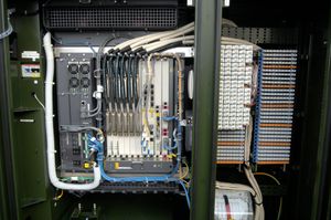 FTTN 또는 FTTC 광케이블 캐비닛 내부. 왼쪽에는 광섬유와 DSLAM이, 오른쪽에는 VDSL과 같은 DSL 형태의 구리선과 펀치다운 블록이 있다.