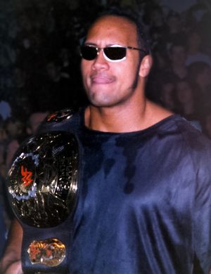 더 락(Dwayne Johnson)이 1999년 스토리라인에서 스톤콜드 스티브 오스틴(Stone Cold Steve Austin)으로부터 훔친 후 스톤콜드 스티브 오스틴의 맞춤형 "스모킹 스컬" 벨트를 들고 있는 사진