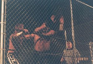 2003년 11월 링 오브 아너(Ring of Honor)의 "The Conclusion" 이벤트에서 레이븐(Raven)과의 케이지 매치(cage match) 중인 CM 펑크(CM Punk)(왼쪽)