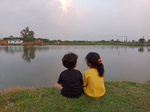 인도 비하르주 아다푸르(Adapur, Bihar, India)의 저녁 연못 근처에 있는 두 자매