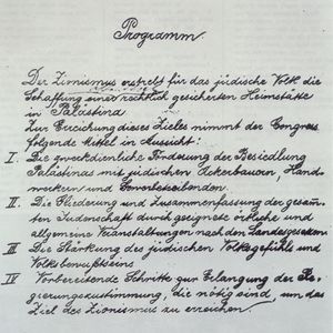 1897년 제1 시온주의 회의에서 승인된 "바젤 강령". 첫 번째 줄은 "시온주의는 공법에 따라 보장된 팔레스타인에 유대인을 위한 보금자리(Heimstätte)를 건설하고자 한다."라고 명시되어 있다.