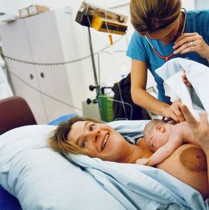 신생아가 간병인이 청진기로 호흡음을 확인하는 동안 휴식을 취하고 있다.