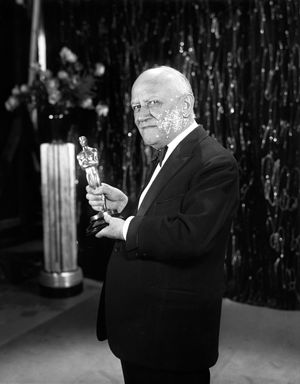 칼 라엠르(Carl Laemmle) 프로듀서가 아카데미 작품상 트로피를 들고 있는 모습