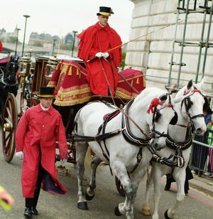 마부, 도보 하인. 마차에는 화려한 해머클로스가 걸려 있습니다.