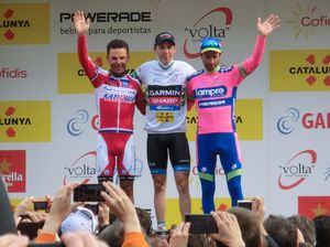 세 명의 선수가 모인 관중에게 손을 흔들고 여러 관중들이 사진을 찍고 있다