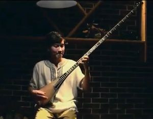 전통 의상을 입은 위구르 남성이 전통 악기인 탐부르를 연주하고 있다.