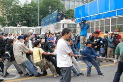 경찰 버스를 밧줄로 잡아당기는 시위대