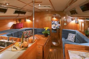 메인 살롱에 접이식 테이블, 왼쪽에 갤리(주방), 오른쪽에 항해 장비실, 그리고 그 너머로 보이는 전방 선실이 있는 크루징 요트 내부