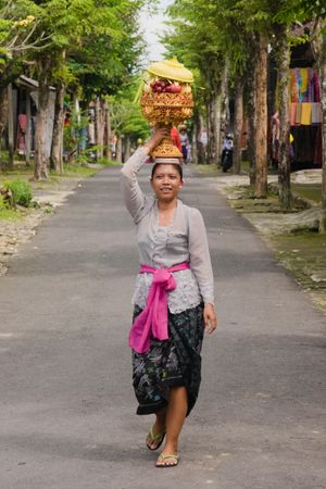 머리에 제물로 과일을 얹고 있는 발리 여성