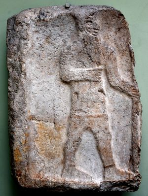 석회암 부조; 비석. 이 특이한 비석은 손에 튤립을 들고 다른 손에는 지팡이 또는 창을 잡고 있는 신원 미상의 아람 왕을 묘사하고 있다. 기원전 11세기. 텔 에스살리히예, 다마스쿠스 출토