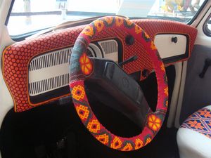 두 개의 스포크가 있는 폭스바겐 비틀 스티어링 휠에 씌워진 밝은 색의 스티어링 휠 커버