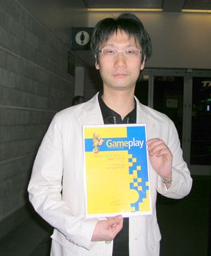 2006년 E3에서 게임플레이지가 수여한 2005년 최우수 스토리 상을 받고 있는 코지마 히데오