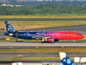 빨간색 앞부분과 남색 뒷부분, 중간에 빨간색에서 남색으로 그라데이션이 있는 비행기, 꼬리에는 남색 에스키모 그림이 있고 동체에는 "MORE TO LOVE"라는 글자가 적혀 있으며, 활주로를 이동하고 있다.