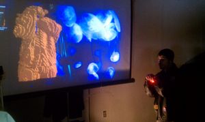 메이커 페어에서의 키넥트 활용 사례. 왼쪽의 시각화는 키넥트를 통해 제공되며, 웨어러블 전자 제어 장치가 장착된 재킷을 입은 사용자(VJ 작업용)를 보여준다.