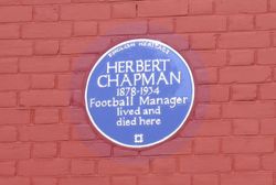 잉글랜드 문화유산(English Heritage) 푸른 명판. 채프먼 전 거주지(헨던) 외벽 부착, 축구 선수/감독 기념 최초 명판.