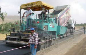 아스팔트 혼합물의 깔기를 담당하는 아스팔트 피니셔. 덤프트럭에서 아스팔트 혼합물이 공급된다.