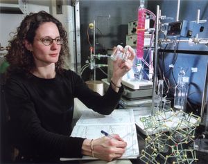 샌디아 국립 연구소(Sandia National Laboratories)의 연구원이 방사성 폐기물 및 산업 금속 정화에 잠재력을 보이는 제올라이트인 SOMS(샌디아 팔면체 분자체) 바이알을 조사하고 있다.