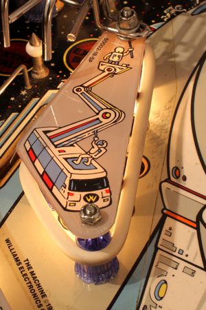 슬링샷에는 고무 밴드가 감겨 있다. 고무 뒤 스위치는 공의 충격을 감지하고 솔레노이드 구동 레버가 공을 튕겨낸다.