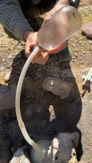 기겐바흐 병을 사용한 희귀 기체 샘플링. 깔때기를 온천 위에 놓아 Tygon 튜브를 통해 샘플의 흐름을 병으로 집중시킨다. 지구화학자가 Teflon 밸브를 사용하여 샘플 유입량을 제어하고 있다. 진공 상태의 기겐바흐 병 내부의 응축 과정에 유의하라.