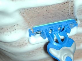 습식면도 중인 장면. 크림을 바른 후 날 면도기로 턱 아래를 면도하고 있다.