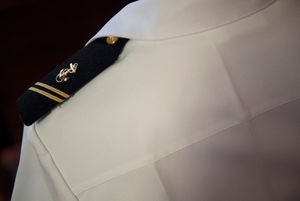 단단한 견장, 셔츠에 견장을 고정하기 위한 두 개의 작은 흰색 고리가 있다