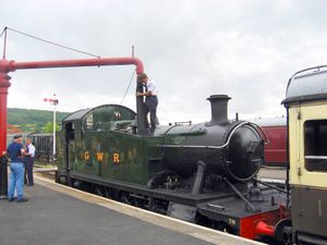 급수 크레인을 사용하여 물을 채우는 기관차