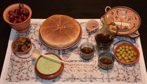 허브 퓨레를 곁들인 연성 치즈(Mixtura cum Caseo)와 부드러운 빵(Hapalos Artos)을 올리브, 포도, 와인과 함께 재현한 모습