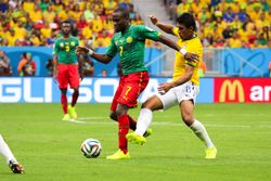 2014년 6월 23일 2014년 FIFA 월드컵에서 동료 랑드리 은구에모가 브라질 미드필더 파울리뉴와 공을 다투는 모습을 니콜라가 배경에서 지켜보고 있다.